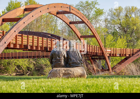 The Tridge spans the confluence of the Chippewa and Tittabawassee Rivers in Chippewassee Park in Midland, Michigan. Couple Sculpture in foreground Stock Photo