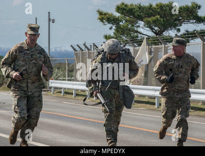 Torii Station, Okinawa (Feb 12, 2017) –Sgt. Maj. Juan Rosario-Montalvo (left) and Sgt. Maj. Michael Barcena motivate soldiers crossing the finish line of the 12-mile ruck march during the US Army Japans best warrior competition. The top competitors of this competition will continue on to compete in a pacific-wide competition in Hawaii. (U.S. Navy photo by Mass Communication Specialist Taylor Mohr) Stock Photo