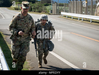 Torii Station, Okinawa (Feb 12, 2017) –Sgt. Maj. Juan Rosario-Montalvo (left) and Sgt.Keila Hernandez  run together to the finish line of the 12-mile ruck march during the US Army Japans best warrior competition. The top competitors of this competition will continue on to compete in a pacific-wide competition in Hawaii. (U.S. Navy photo by Mass Communication Specialist Taylor Mohr) Stock Photo