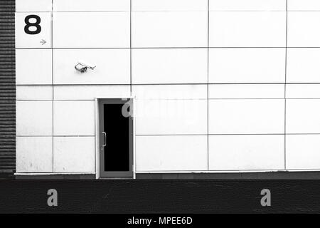 The wall of the building, the door and the CCTV camera. Security. Black and white background. Stock Photo