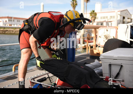 Petty Officer 2nd Class Lyman Dickinson, an aviation survival technician at Coast Guard Sector San Diego, readies equipment to transport a simulated victim during a mass casualty at sea training session on board Coast Guard Cutter Petrel at Sector San Diego on February 8, 2017. The training was aimed at preparing rescue swimmers to save lives by handling multiple casualties in close quarters on an unfamiliar vessel at sea. (U.S. Coast Guard photo by Petty Officer 3rd Class Joel Guzman/released) Stock Photo