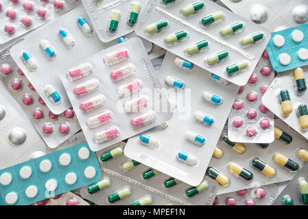 Many multicolored pills in silver blister packs. Pharmaceutical preparations, located in the form of a background. Top view, flat lay Stock Photo