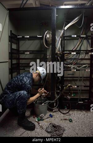 Air Traffic Controller aboard USS John C. Stennis (CVN 74) drains beverage lines on the carrier’s mess decks in preparation for disposal and replacement as part of a planned incremental availability. The Nimitz-class aircraft carrier, currently in port, is undergoing maintenance and upgrades to ensure operational readiness. The procedure supports fleet sustainability, shipboard sanitation, and crew habitability while aligning with scheduled maintenance and Navy operational standards. Stock Photo
