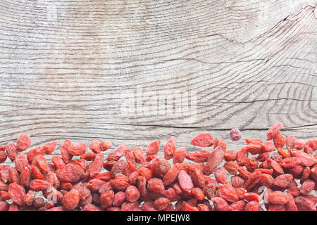 Goji berries on wood surface with patina, oak wood texture background copy space. Stock Photo