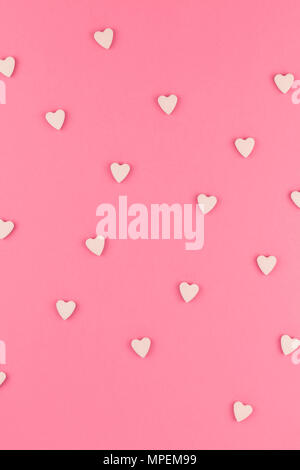 Valentines day pattern background flat lay top view of pink heart shaped candies scattered on pink background love wedding concept