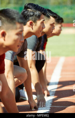 close-up of faces of young asian adult runners on starting line. Stock Photo