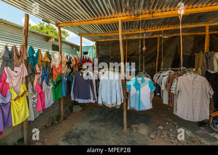 A tourist browses clothes in an informal shop in Inhassoro Mozambique. Stock Photo