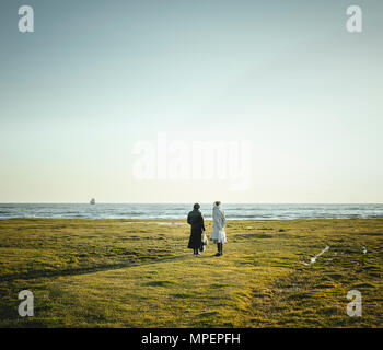 Two women standing at the coast looking at the horizon, black Sea coast, near Okhamchira, Abkhazia, Georgia Stock Photo