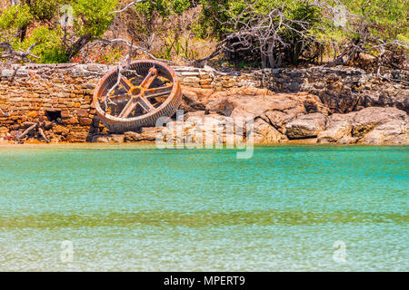 Old rusty Steamboat Wheel on Morro Island. It is an island attached to Taboga island. It is a volcanic island in the Gulf of Panama. It is a tourist d Stock Photo