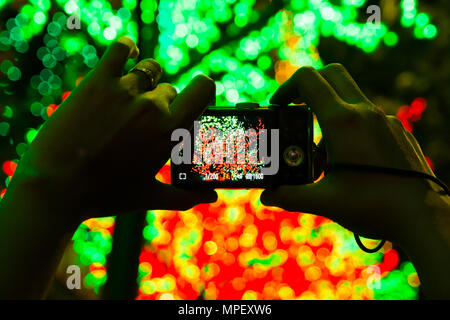 camera taking photos of led light in background creating bokeh. Stock Photo