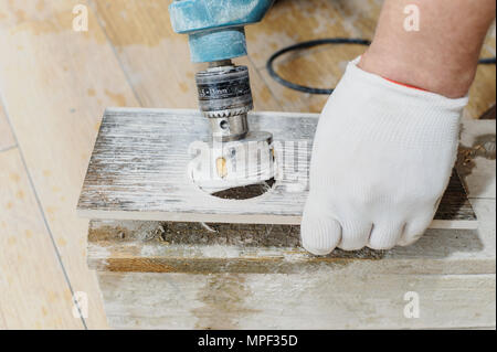 Tiler carves a hole in the tile using a diamond crown. Stock Photo