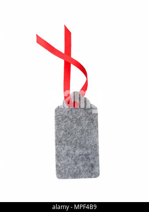 Christmas gift tag tied with red ribbon. Label from gray felt isolated on white background. Stock Photo