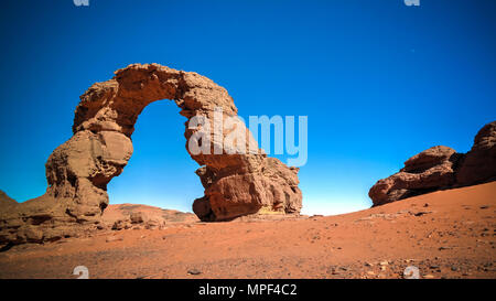 Arch Rock formation aka Arch of Africa or Arch of Algeria with moon at Tamezguida in Tassili nAjjer national park, Algeria Stock Photo