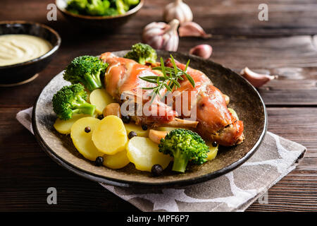 Roasted rabbit legs garnished with potato and broccoli Stock Photo
