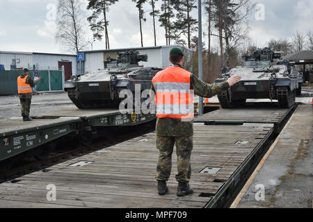 German soldiers with the 122nd Mechanized Infantry Battalion, 12th Armored Brigade, 10. Panzer Division, load tracked Marder infantry fighting vehicles onto railroad carts at the 7th Army Training Command’s Grafenwoehr Tower Barracks railhead station, Germany, Feb. 21, 2017. The unit deploys to the Baltics as part of NATO's Enhanced Forward Presence. (U.S. Army photo by Visual Information Specialist Gertrud Zach) Stock Photo