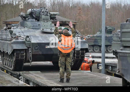 German soldiers with the 122nd Mechanized Infantry Battalion, 12th Armored Brigade, 10. Panzer Division, load tracked Marder infantry fighting vehicles onto railroad carts at the 7th Army Training Command’s Grafenwoehr Tower Barracks railhead station, Germany, Feb. 21, 2017. The unit deploys to the Baltics as part of NATO's Enhanced Forward Presence. (U.S. Army photo by Visual Information Specialist Gertrud Zach) Stock Photo