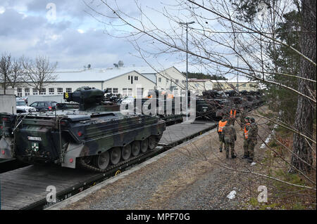 German soldiers with the 122nd Mechanized Infantry Battalion, 12th Armored Brigade, 10. Panzer Division, load tracked Marder infantry fighting vehicles onto railroad carts at the 7th Army Training Command’s Grafenwoehr Tower Barracks railhead station, Germany, Feb. 21, 2017. The unit deploys to the Baltics as part of NATO's Enhanced Forward Presence. (U.S. Army photo by Visual Information Specialist Gertrud Zach) Stock Photo