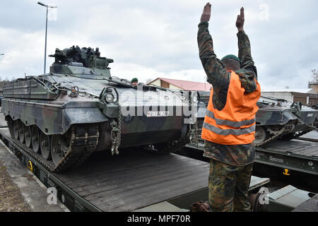 German soldiers with the 122nd Mechanized Infantry Battalion, 12th Armored Brigade, 10. Panzer Division, load tracked Marder infantry fighting vehicles onto railroad carts at the 7th Army Training Command’s Grafenwoehr Tower Barracks railhead station, Germany, Feb. 21, 2017. The unit deploys to the Baltics as part of NATO's Enhanced Forward Presence. (U.S. Army photo by Visual Information Specialist Gertrud Zach) Stock Photo