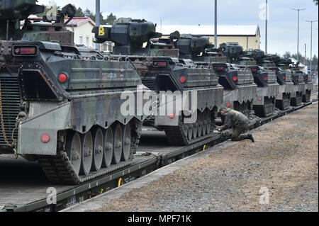 German soldiers with the 122nd Mechanized Infantry Battalion, 12th Armored Brigade, 10. Panzer Division, load tracked Marder infantry fighting vehicles onto railroad carts at the 7th Army Training Command’s Grafenwoehr Tower Barracks railhead station, Germany, Feb. 21, 2017. The unit deploys to the Baltics as part of NATO's Enhanced Forward Presence. (U.S. Army photo by Visual Information Specialist Gertrud Zach) Stock Photo