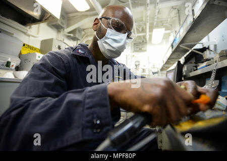 PACIFIC OCEAN (Feb. 19, 2017) Hospital Corpsman 2nd Class Terrell Conley, a native of Bainbridge, Ga., crafts and polishes a hard night guard for tooth alignment on board the aircraft carrier USS Nimitz (CVN 68). Nimitz is currently underway conducting fleet replacement squadron carrier qualifications. (U.S. Navy photo by Mass Communication Specialist 3rd Class Colby S. Comery/Released) Stock Photo