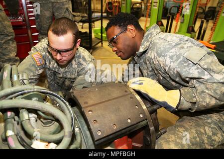 Spc. Christopher Norwood with the 275th Quartermaster Company at Fort Pickett, Va., and Sgt. Marquett Evans with the 422nd Civil Affairs Battalion at Greensboro, N.C., both students at Regional Training Site-Maintenance in the Wheeled Vehicle Mechanics Course, work on a project Feb. 10, 2017, at Fort McCoy. During the course, students learn to complete all basic concepts required to be certified as an Army wheeled-vehicle mechanic. This includes performing field-level maintenance on automotive wheeled vehicles and conducting wheeled-vehicle operations; receiving an introduction to troubleshoot Stock Photo