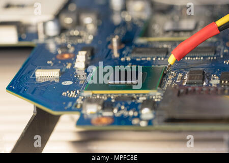 Laptop repair. Replacement chip graphics card on the infrared soldering station. Photo of motherboard repair Close-up. Stock Photo