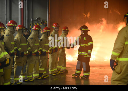 170222-N-BN978-002 GREAT LAKES, Ill. (Feb. 22, 2017) A group of students fight a fire at the new Fire Fighting Trainer at Surface Warfare Officers School Unit Great Lakes. Over 50 students took part in the two day training that will train more than 10,800 students and staff members take part in the training annually. (U.S. Navy photo by Brian Walsh/Released) Stock Photo