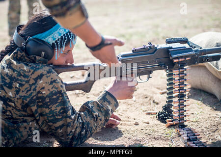 A local female Manbij Military Council trainee fires a 7.62mm PK machine gun during marksmanship training Feb. 21, 2017, at Sanaa Training Center in Northwest Syria. The instruction is 20 days long to include basic rifle marksmanship, and squad level weapons and movement techniques. This is the first cycle of women to graduate and join the MMC. The course is administered by Special Operations Joint Task Force – Operation Inherent Resolve trainers. (U.S. Army photo by Master Sgt. Mark Burrell) Stock Photo