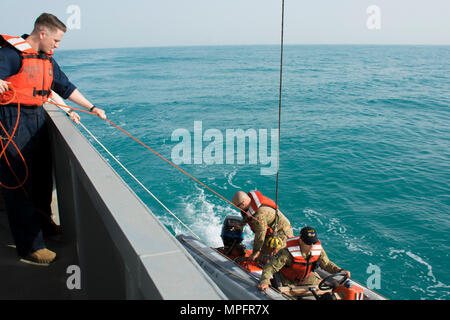 Kuwait-The Soldiers from the LCU2013 Churubusco- a Landing Craft Utility vessel from Detachment 1, 481st Transportation Company, California, hoist a small watercraft to the seas’ surface before speeding to the personnel acting lost at sea during a personnel recovery training mission replicating a downed aircraft scenario, Feb. 13.   (Photo by Army Sgt. 1st Class Suzanne Ringle/Released) Stock Photo