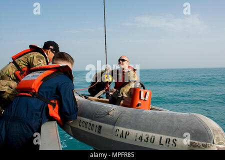 Kuwait-The Soldiers from the LCU2013 Churubusco- a Landing Craft Utility vessel from Detachment 1, 481st Transportation Company, California, hoist a small watercraft to the seas’ surface before speeding to the personnel acting lost at sea during a personnel recovery training mission replicating a downed aircraft scenario, Feb. 13.   (Photo by Army Sgt. 1st Class Suzanne Ringle/Released) Stock Photo