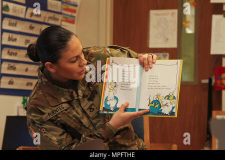 Pfc. Elise M. Fuentes, a military police with 218th Military Police Company, 716th MP Battalion, 101st Airborne Division (Air Assault) Sustainment Brigade, 101st Abn. Div., reads “One Fish, Two Fish, Red Fish, Blue Fish” by Dr. Seuss, March 2, 2017, to the first grade students of Marshall Elementary School on Fort Campbell, Kentucky. Fuentes, along with six other Soldiers from the battalion, volunteered to read for Marshall Elementary School’s Read Across America Day. (U.S. Army photo by Sgt. Neysa Canfield/101st Airborne Division Sustainment Brigade Public Affairs) Stock Photo