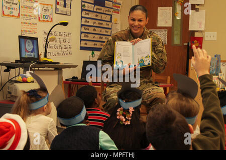 Pfc. Elise M. Fuentes, a military police with 218th Military Police Company, 716th MP Battalion, 101st Airborne Division (Air Assault) Sustainment Brigade, 101st Abn. Div., shows first grade students the illustrations in a book, March 2, 2017, during Read Across America Day at Marshall Elementary School on Fort Campbell, Kentucky. Marshall Elementary School celebrated the 20th anniversary of Read Across America by inviting Soldiers from 716th MP Bn. to read to the elementary students and by putting together a production of Dr. Seuss’s “The Cat in the Hat.” (U.S. Army photo by Sgt. Neysa Canfie Stock Photo