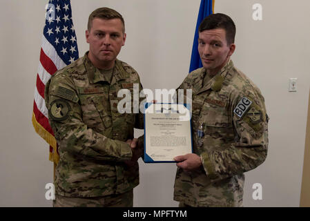 Maj. Michael Warren, 824th Base Defense Squadron commander, awards Staff Sgt. David Green, 824th BDS fireteam leader, with an achievement medal, April 10, 2017, at Moody Air Force Base, Ga. Green received the medal for his act of heroism when he helped a trapped victim during an off-base vehicle incident. Stock Photo