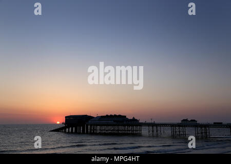 Cromer pier, Norfolk. 22nd May, 2018. UK Weather: The sun rises behind Cromer pier on a beautiful start to the day in Cromer, North Norfolk, on May 22, 2018. Credit: Paul Marriott/Alamy Live News Stock Photo