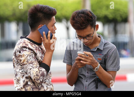 Yangon, Myanmar. 23rd May, 2018. Two boys use mobile phones in Yangon, Myanmar, May 23, 2018. Mobile phone usage rate increased to over 110.43 percent so far in Myanmar, according to the Ministry of Transport and Communications on Tuesday. Credit: U Aung/Xinhua/Alamy Live News Stock Photo