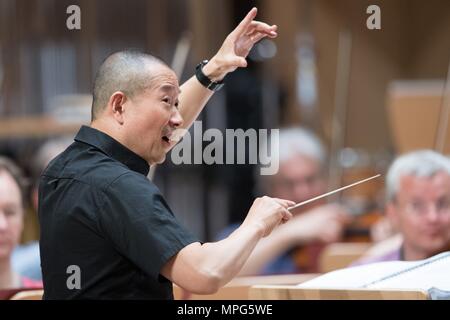 23 May 2018, Germany, Dresden: Chinese composer Tan Dun (c) stands on stage at a rehearsal of 'Buddha Passion' at the Kulturpalast. Musicians of the Munich Philharmonics and singers of the International Choir Academy Luebeck perform the piece. Photo: Sebastian Kahnert/dpa Stock Photo