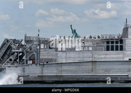 New York, USA. 23rd May, 2018. The USNS City of Bismarck joins the Parade of Ships as it makes its way past the Statue of Liberty on the opening day of Fleet Week on May 23, 2018 in New York City. Credit: Erik Pendzich/Alamy Live News