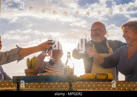 mature men and women cheers with wine outdoor in patio terrace rooftop for celebrate vacation or birthday or event. elderly lifestyle happy day life c Stock Photo