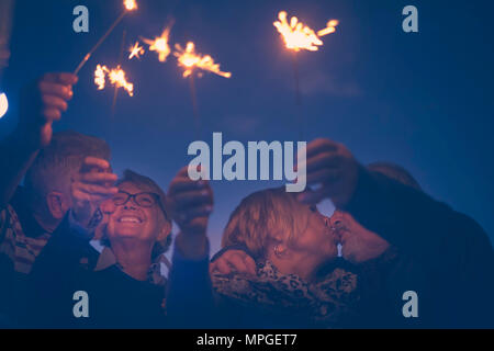 celebration party for holiday night or new year eve 2019. group of aged men and women people with fire sparks. everybody kissing and having a lot of f Stock Photo