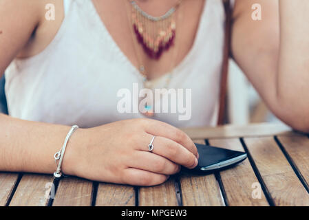 Midsection of woman using mobile phone. Focus on hand Stock Photo