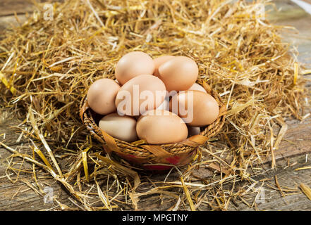 eggs in hay basket basket with straw Stock Photo