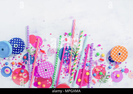 Cocktail straws, jar caps, confetti and candies in a colorful party concept, dessert and catering supplies on a light background with copy space from  Stock Photo