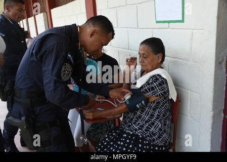 A police officer with the San Pedro Sula Metropolitan Police Unit Medical Brigade conducts a medical assessment during a medical civic action program mission in San Pedro Sula, Honduras, Feb. 18, 2017. Approximately 1,175 patients were seen in this one-day collaboration effort between local police, JTF-Bravo, local providers and private organizations. Working with Honduran police forces on joint exercises solidifies JTF-Bravo as a Partner-of-Choice for collaborative actions. (U.S. Air Force photo by Capt Denise Hauser) Stock Photo