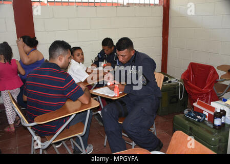 A police officer with the San Pedro Sula Metropolitan Police Unit Medical Brigade conducts a medical assessment during a medical civic action program mission in San Pedro Sula, Honduras, Feb. 18, 2017. Approximately 1,175 patients were seen in this one-day collaboration effort between local police, JTF-Bravo, local providers and private organizations. Working with Honduran police forces on joint exercises solidifies JTF-Bravo as a Partner-of-Choice for collaborative actions. (U.S. Air Force photo by Capt Denise Hauser) Stock Photo