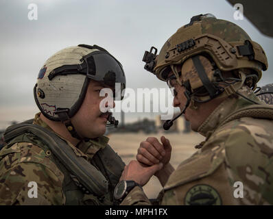 A U.S. Navy sailor from Helicopter Sea Combat Squadron 5 speaks to a French Air Force member prior to a training mission during Exercise Emerald Warrior 17 at Hurlburt Field, Fla., Feb. 28, 2017. Emerald Warrior is a U.S. Special Operations Command exercise during which joint special operations forces train to respond to various threats across the spectrum of conflict. (U.S. Air Force photo by Staff Sgt. Cory D. Payne) Stock Photo