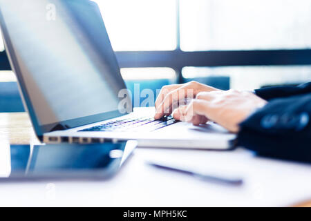 Hands of businessman working on his computer with bright light coming from window with blue color tone, good for business or technology concept Stock Photo
