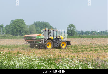 Agricultural vehicle spreading powder on fallow land Stock Photo