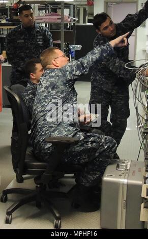 Petty Officer 2nd Class Lucas Voie prepares to lower a line to a Stock