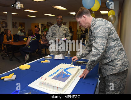 Col. C. Mike Smith, 81st Training Wing vice commander, cuts a cake during the Air Force Aid Society 75th Anniversary Celebration at the Sablich Center March 10, 2017, on Keesler Air Force Base, Miss. Gen. Henry ‘Hap’ Arnold founded the relief organization in 1942, which is the official charity of the U.S. Air Force and exists to meet the unique needs of Total Force Airmen, their families and widows or widowers. (U.S. Air Force photo by Kemberly Groue) Stock Photo