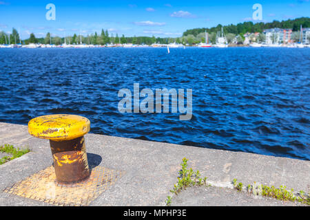 Yellow mooring bollard mounted in concrete embankment. Lappeenranta, Finland. Saimaa lake coast Stock Photo